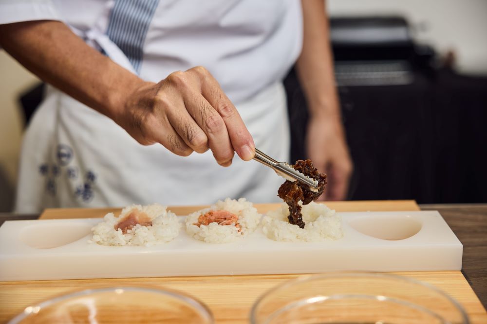 おにぎり淺草宿六料理長一一將內餡包入飯糰中。