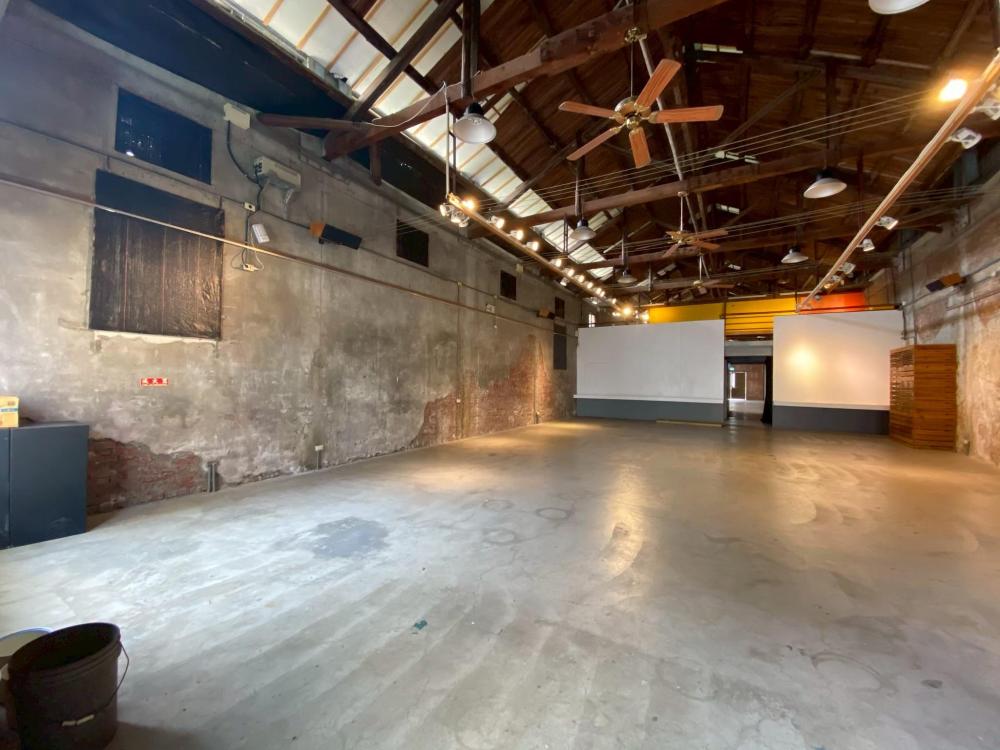 新港文化館25號倉庫刻意保留了原始的木造屋架、斑駁紅磚、水泥斷痕與通風小氣窗。