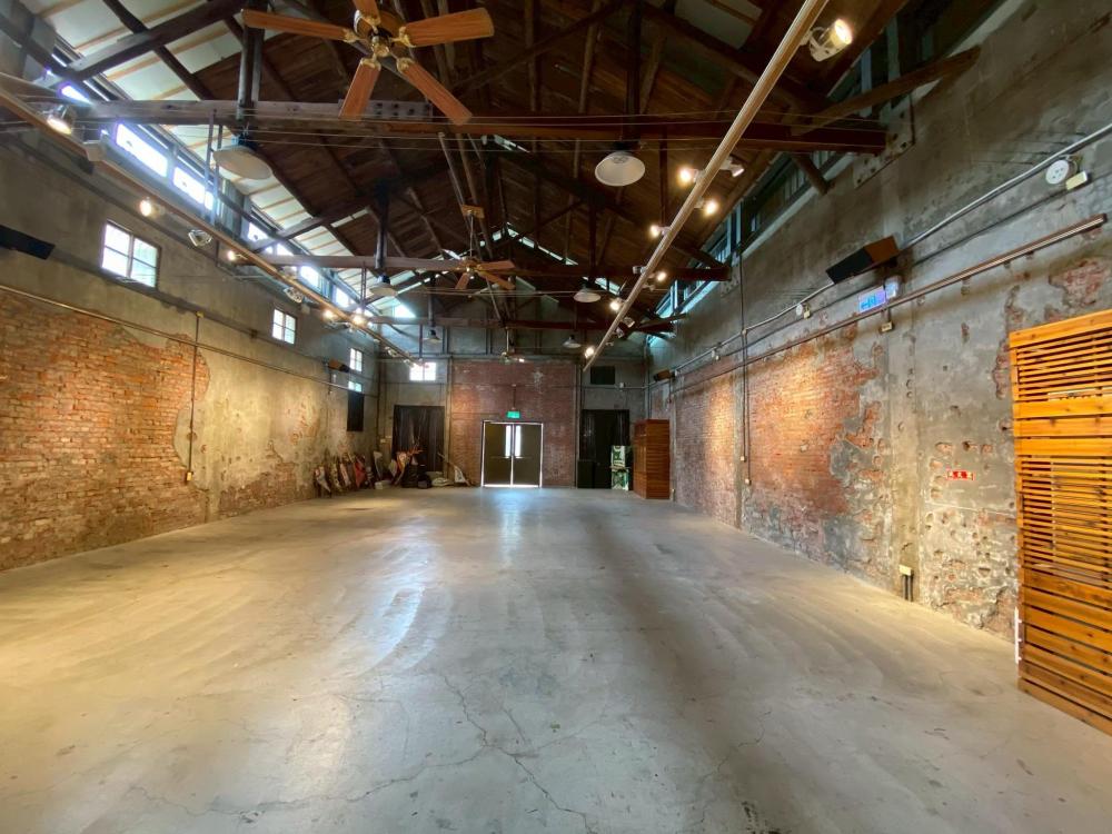 新港文化館25號倉庫刻意保留了原始的木造屋架、斑駁紅磚、水泥斷痕與通風小氣窗。