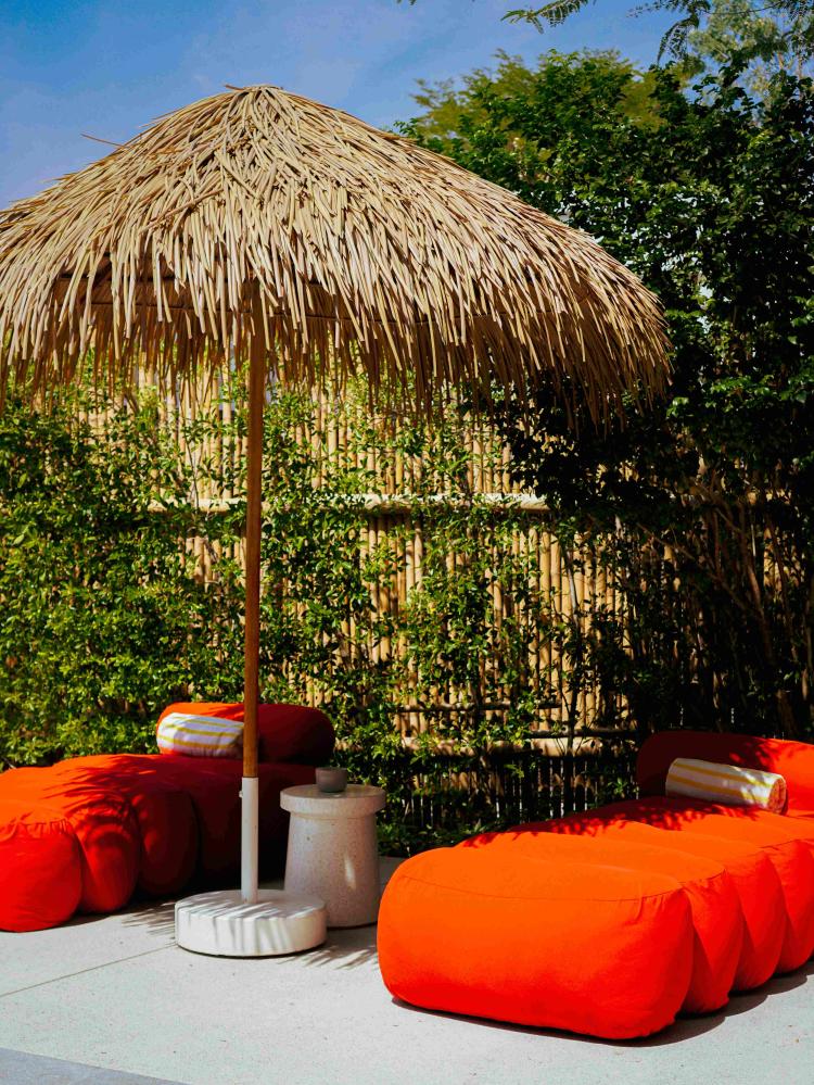 圖說：亮橘色戶外座椅與熱帶植栽交織，展現設計與度假氛圍的自然融合。