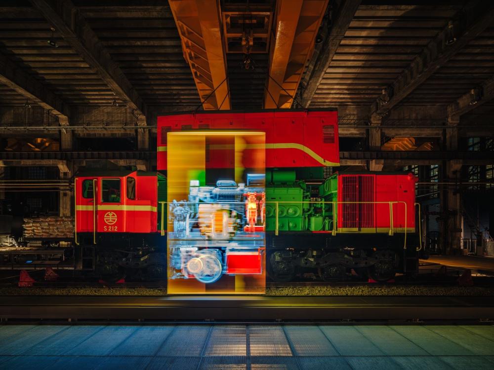 夜間燈光與展示影像映照S212號柴電機車，呈現車輛與工場展演結合的視覺效果。照片提供：當若科技藝術。