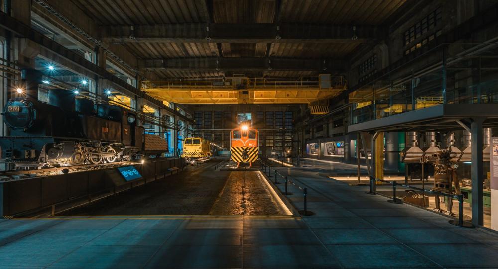 夜間燈光映照下的柴電工場展場,展現車輛,機具與展示空間交織的夜間風貌