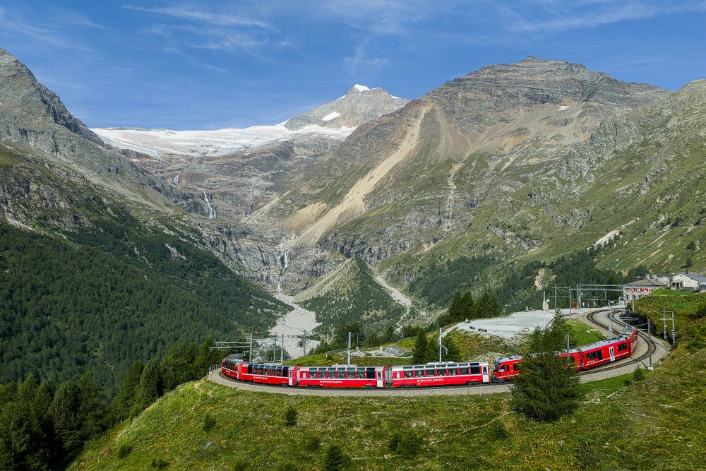 鮮紅色列車從瑞士庫爾（Chur）或聖莫里茨（St. Moritz）出發，沿著雷蒂亞鐵路（Rhätische Bahn, RhB）的阿爾布拉與伯連納路線一路向南