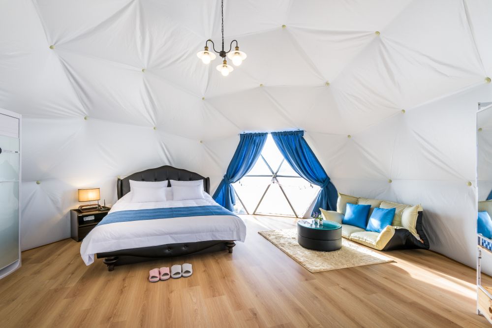3-2. 韓國濟州「Jeju Starlight Glamping」當夜幕低垂，旅人在溫暖帳篷內即可透過全景玻璃窗，將璀璨星空與遠方海岸線的夜色盡收眼底（圖片由 Booking.com 提供）